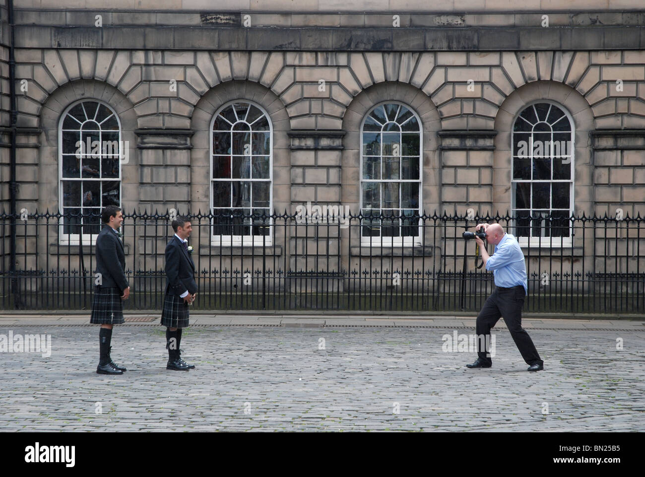 Wedding photographer photographing wedding guests in kilts on the High Street in Edinburgh Stock Photo