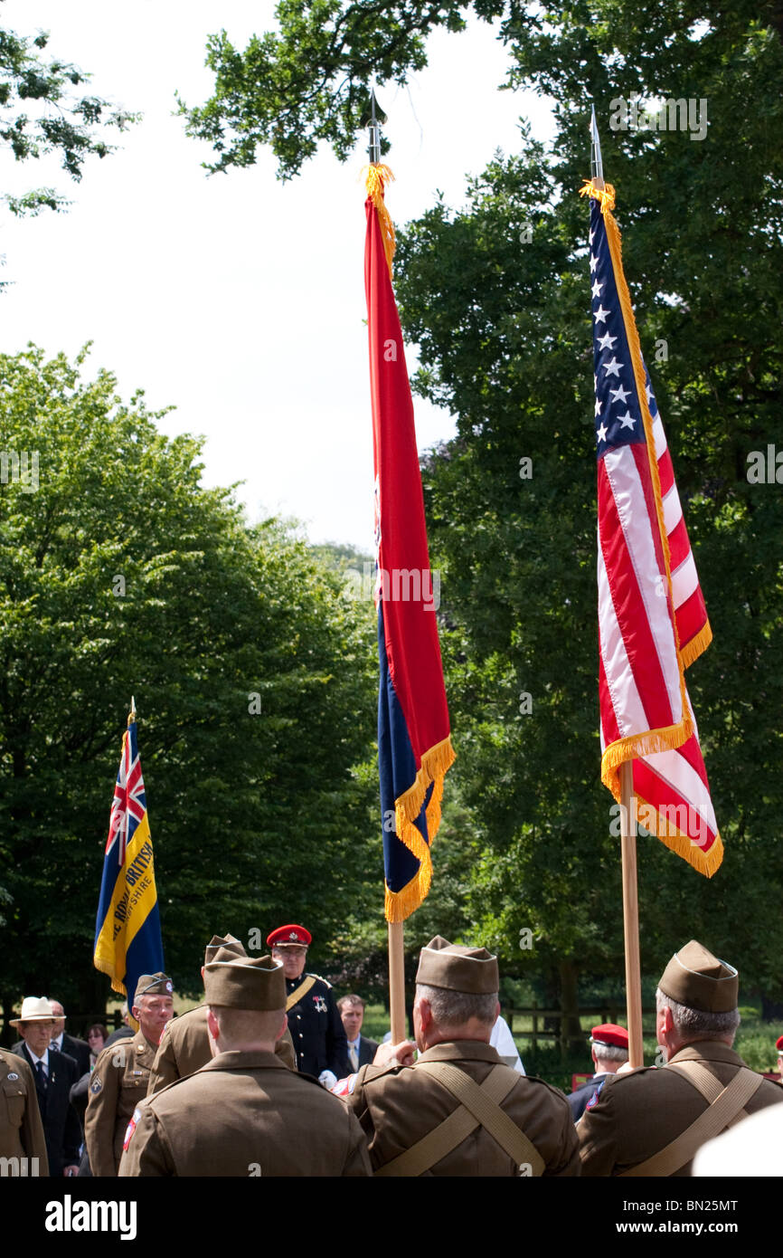 Veteran soldiers holding the American Airborne Army regiment and American stars and stripes flag during a memorial service Stock Photo