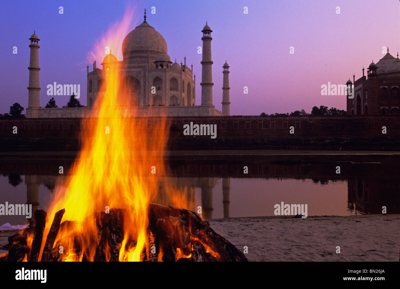 A funeral pyre at the holy site of the Yamuna River across from the Taj Mahal Agra India Stock