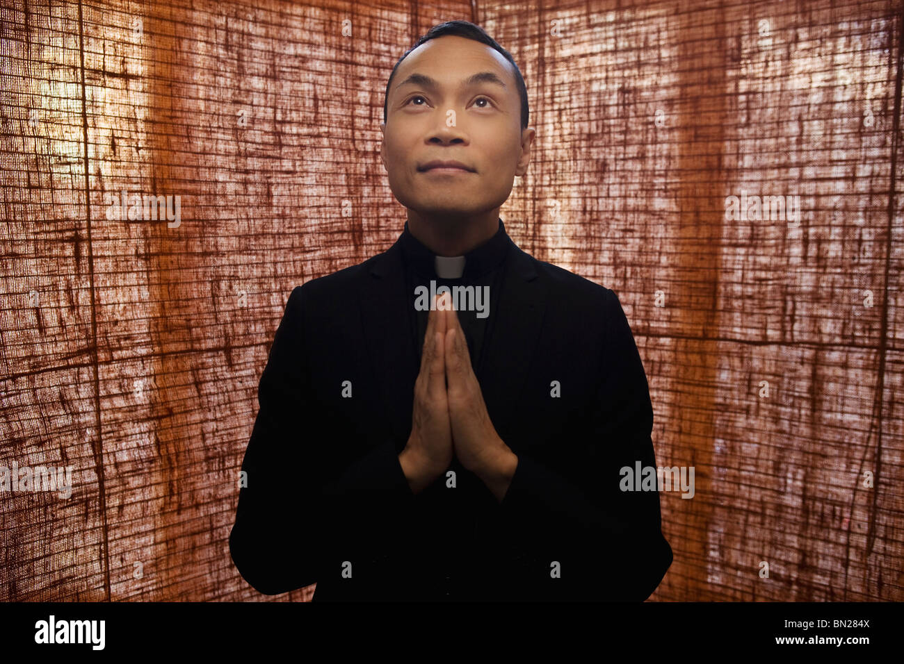 Pacific Islander priest praying Stock Photo