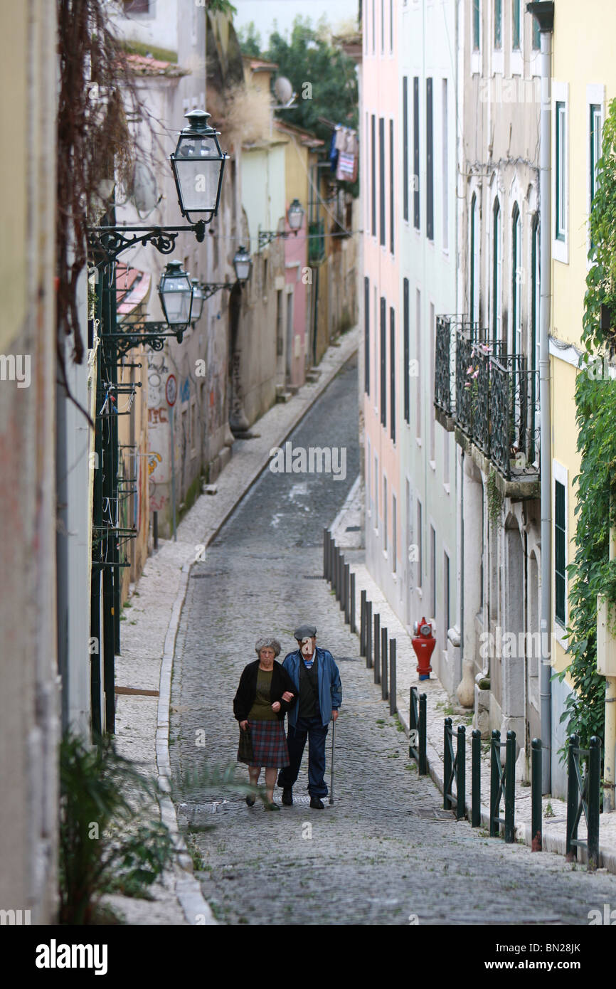 Elderly couple walking in a narrow street of the Barrio Alto (old town) district of Lisbon, Portugal Stock Photo