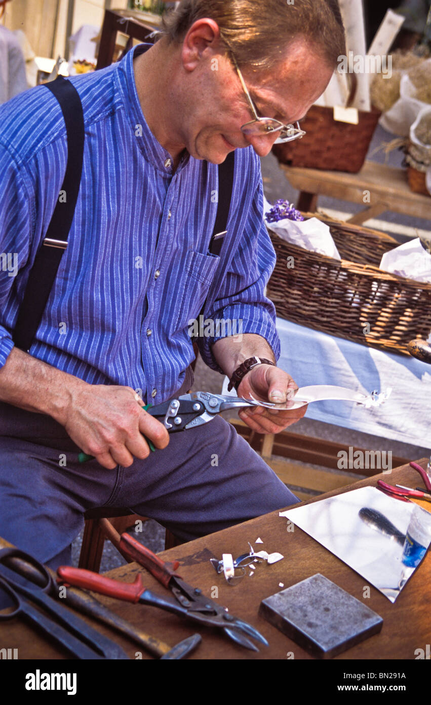 One blue shirted crafts man making tin ware. Stock Photo