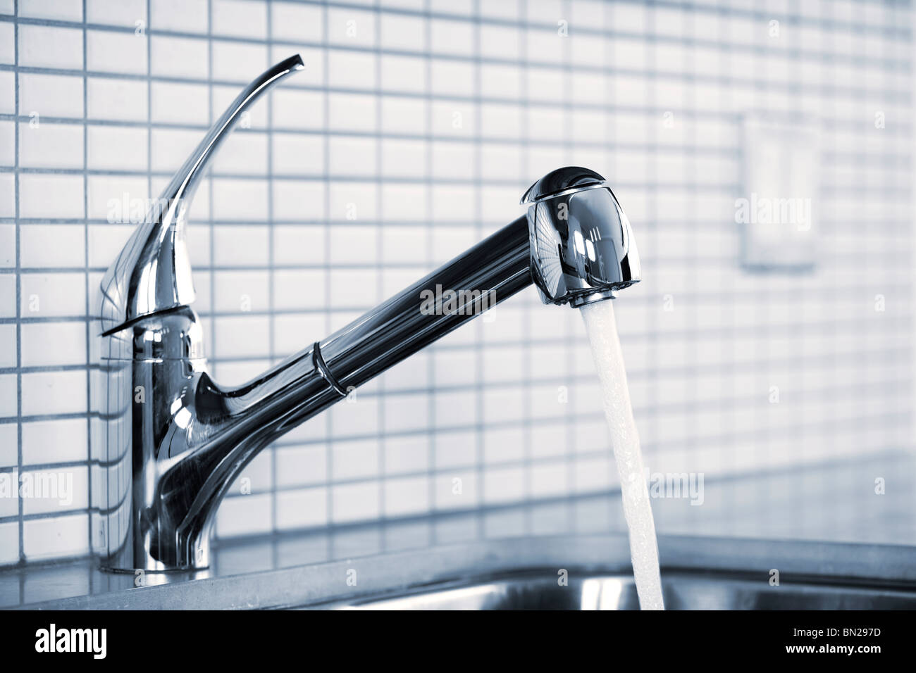 Stainless steel kitchen faucet and sink with running water Stock Photo