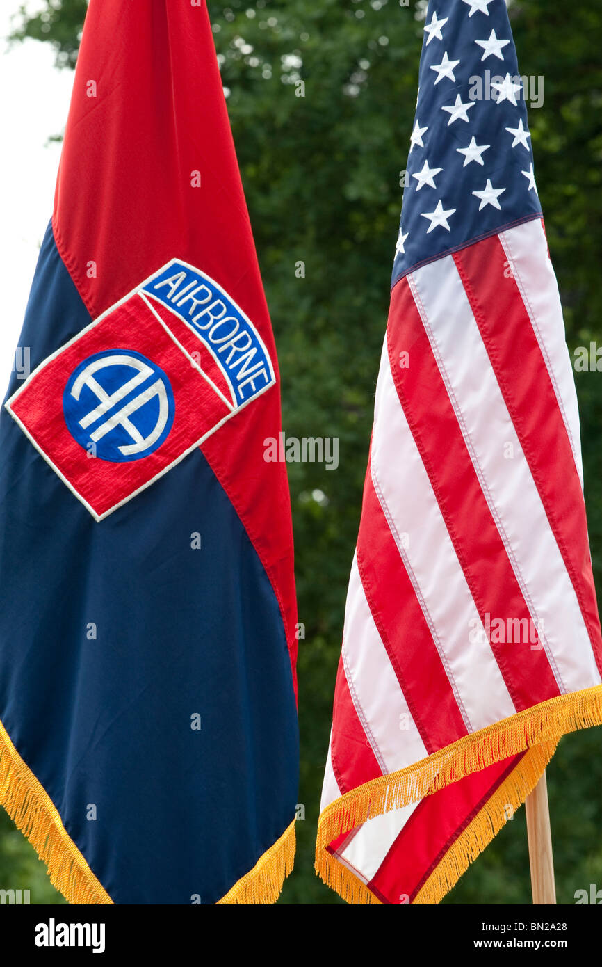Veteran soldiers holding the American Airborne Army regiment and American stars and stripes flag during a memorial service Stock Photo