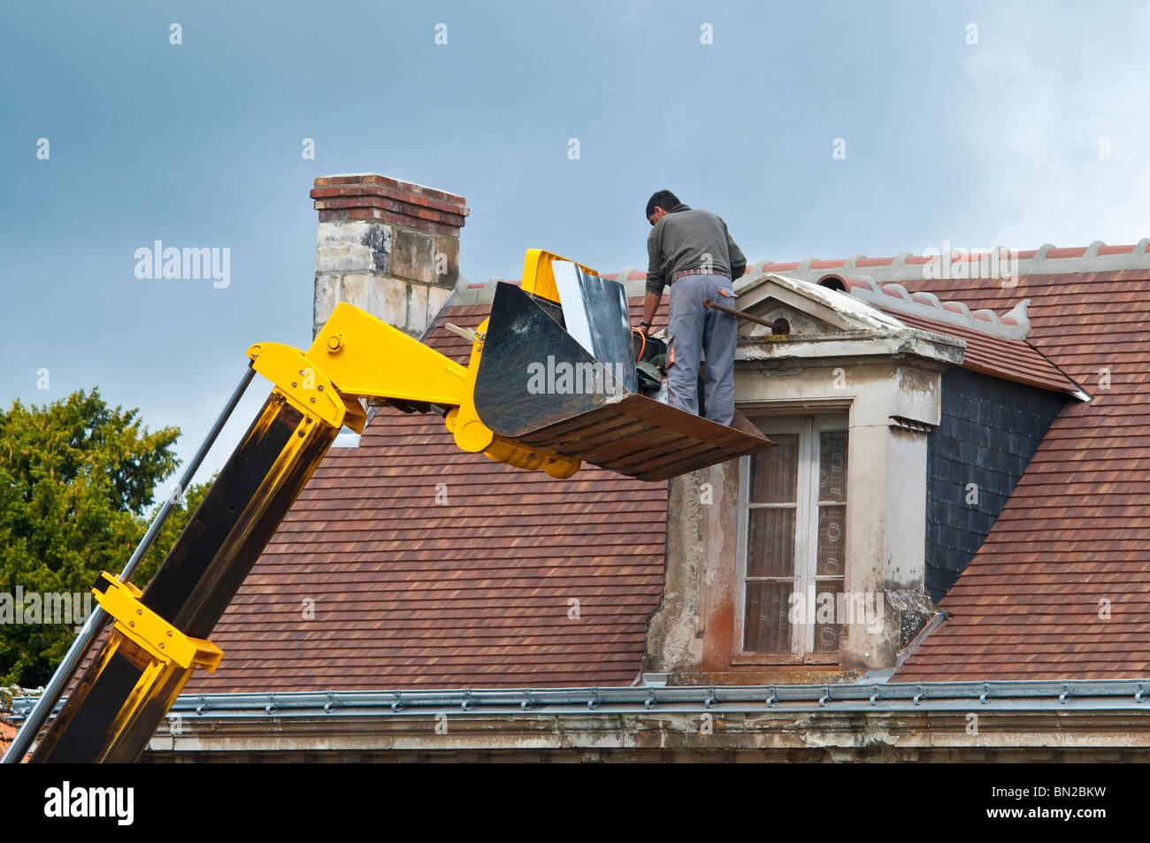 Contractor repairing attic dormer roof / no safety equipment or helmet - France. Stock Photo