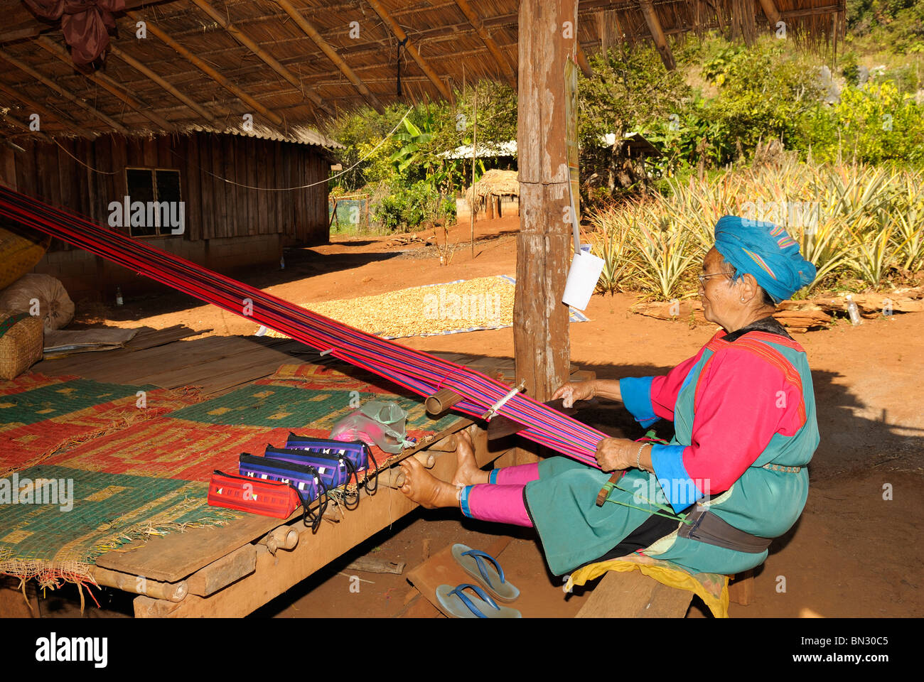 Portrait of a Lisu woman using a weaving-loom and wearing traditional clothes in Dao city, hill tribe, near Chiang Mai, Thailand Stock Photo
