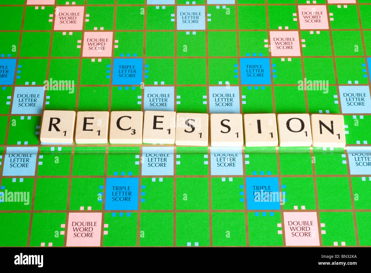 Scrabble board showing word RECESSION horizontally. Stock Photo