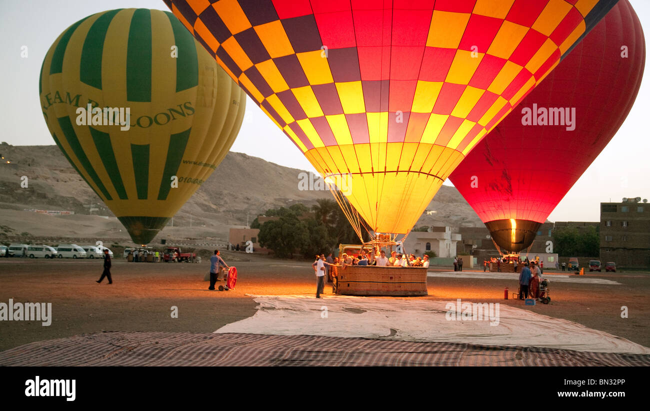 Three hot air balloons preparing to lift off at dawn, Luxor, Egypt Stock Photo