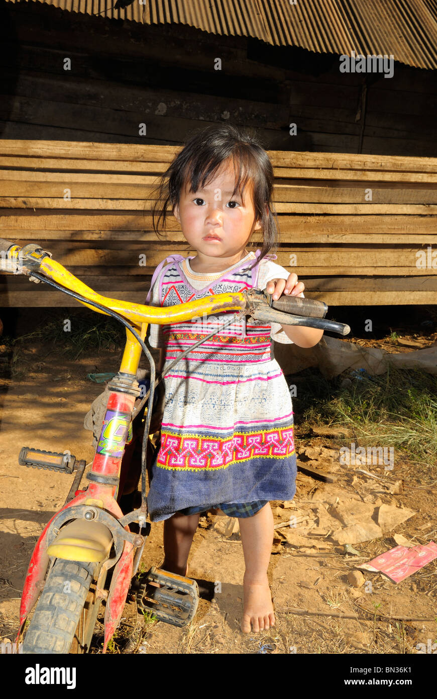 Portrait of a girl holding her bike in a Hmong village, Mae Hong Son ...