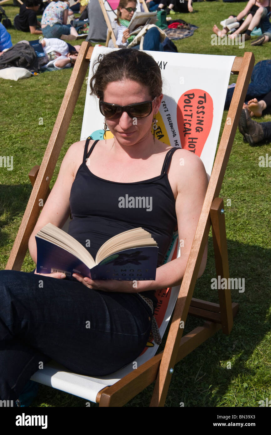 Young woman in black top reading book sitting in deckchair in summer sunshine at Hay Festival 2010 Hay on Wye Powys Wales UK Stock Photo