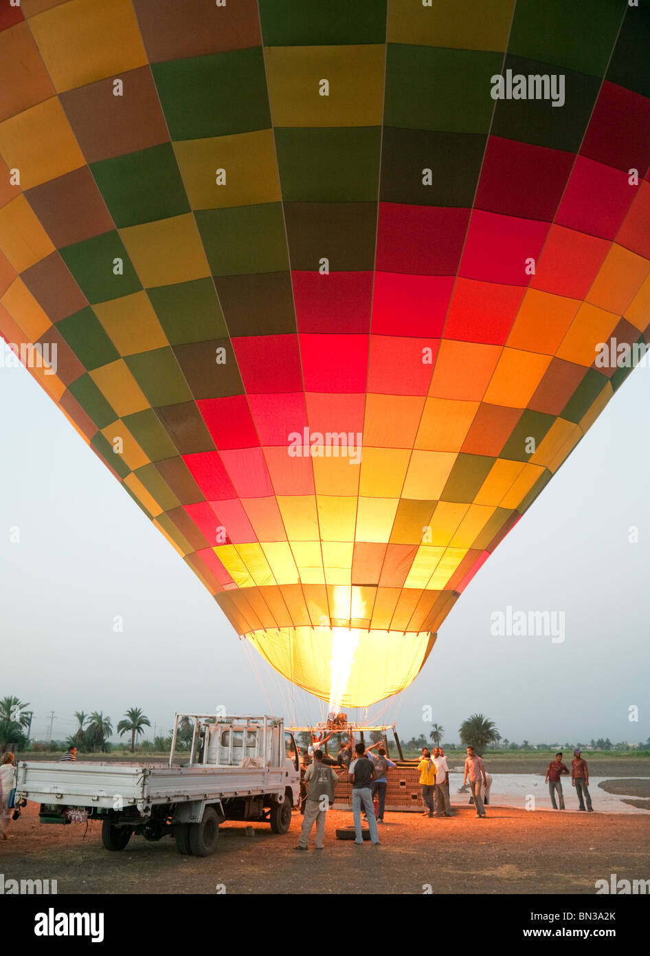 A hot air balloon preparing to lift off at dawn, Luxor, Egypt Stock Photo