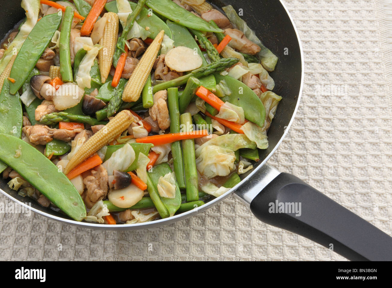Chinese teriyaki chicken stir fry with vegetables in wok Stock Photo