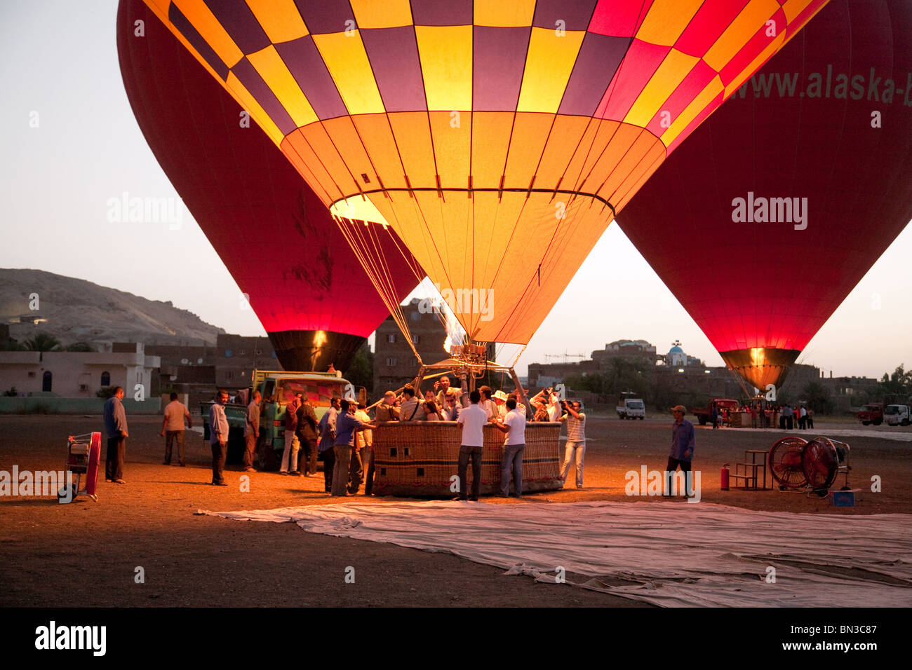 Three hot air balloons preparing to lift off at dawn, Luxor, Egypt, Africa, concept of Adventure holiday Stock Photo