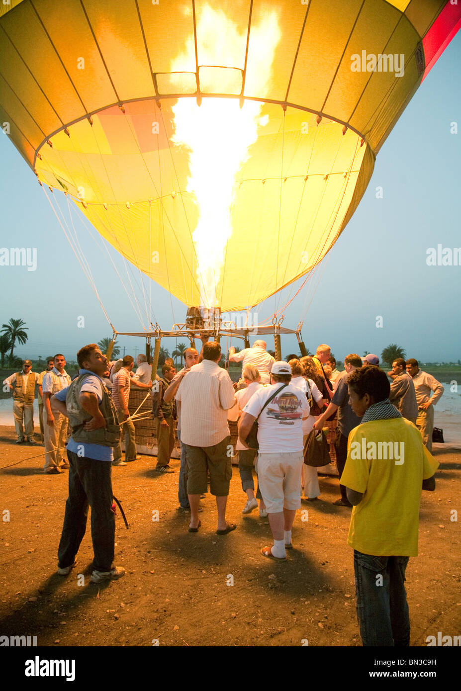 A hot air balloon and passengers preparing to lift off at dawn, Luxor, Egypt Stock Photo