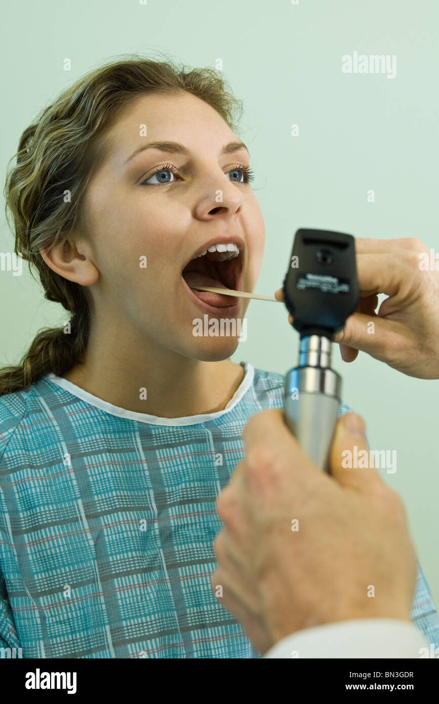 Using ophthalmoscope to examine patient's throat Stock Photo