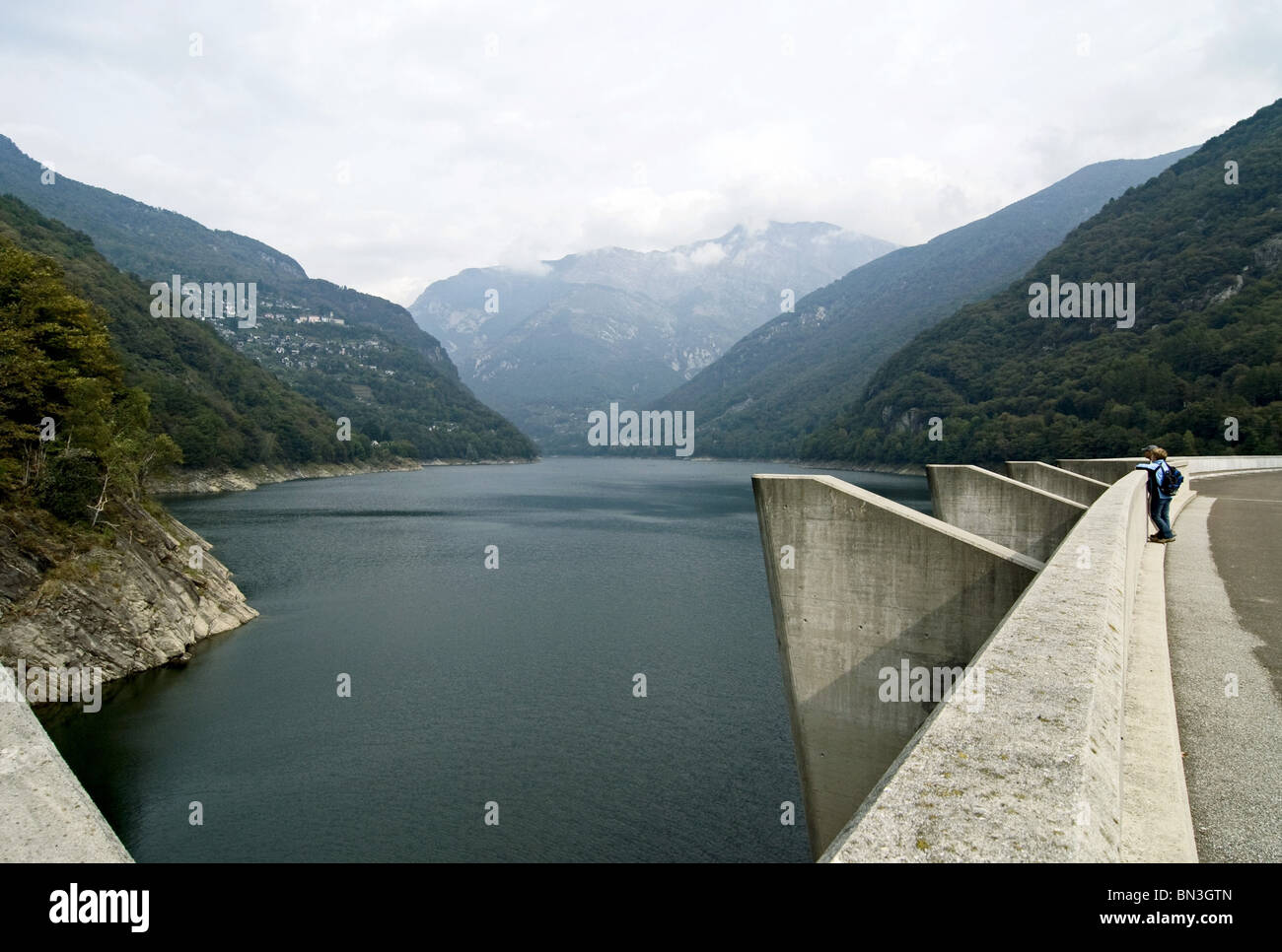 Couple standing on reservoir dam, view of the lake Lago di Vogorno, Tessin Canton, Switzerland, elevated view Stock Photo