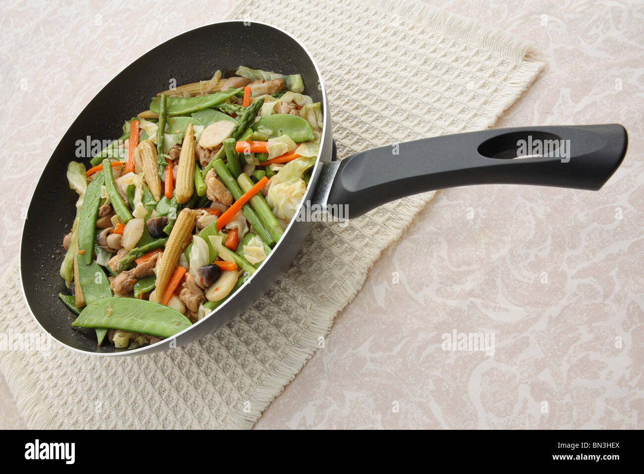 Chinese vegetable stir fry in wok on a table Stock Photo