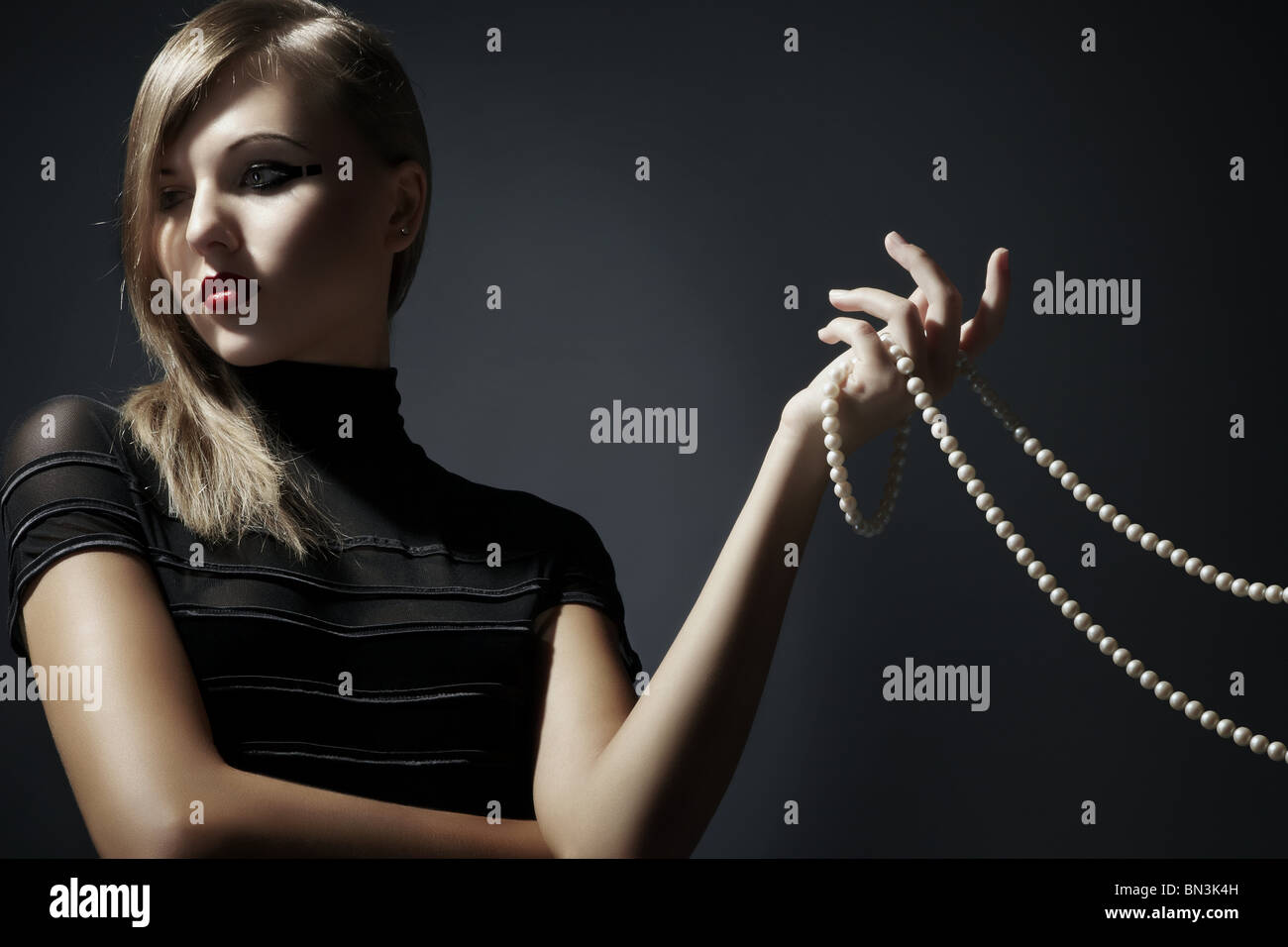 Young woman holding pearl necklace in her hand Stock Photo