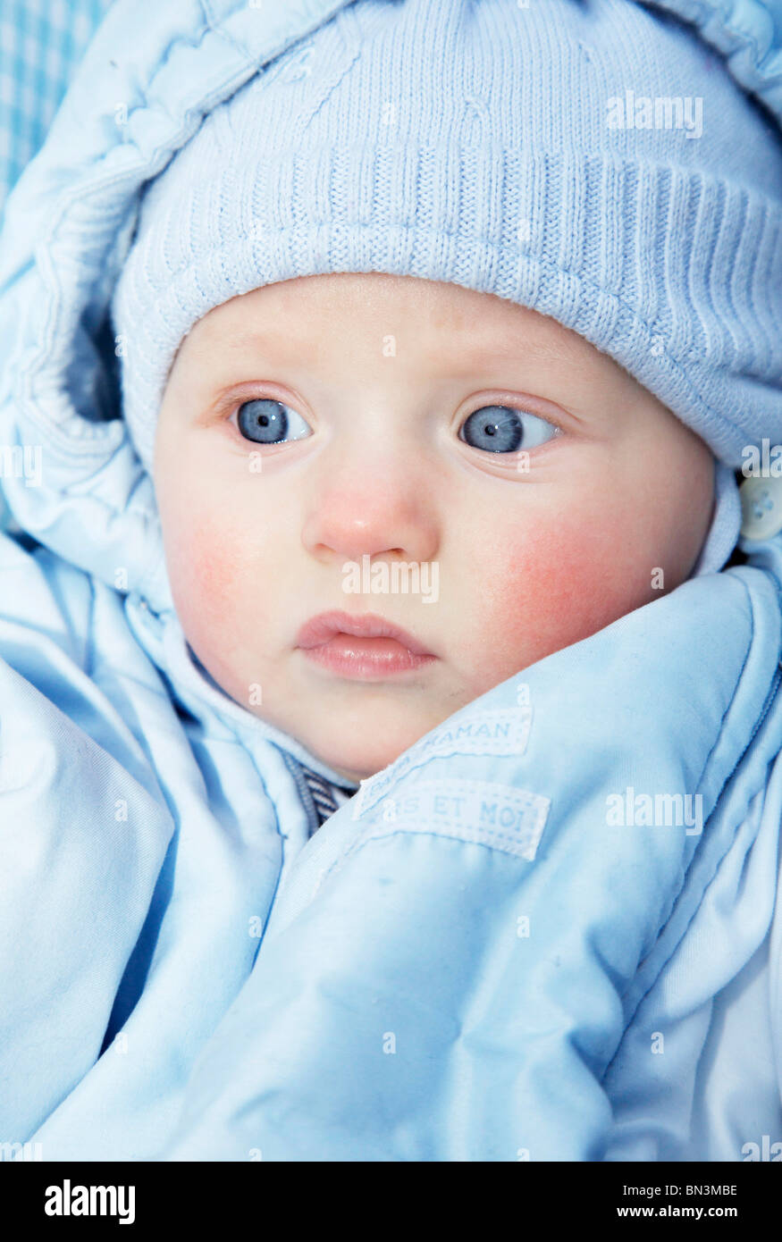 Baby wearing a blue cap and jacket, portrait Stock Photo