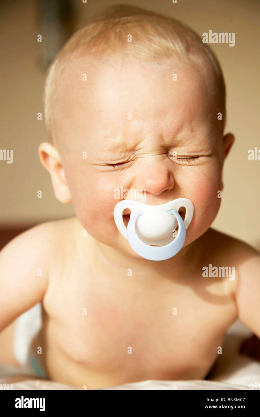 Baby boy with dummy in his mouth crying, portrait Stock Photo Alamy