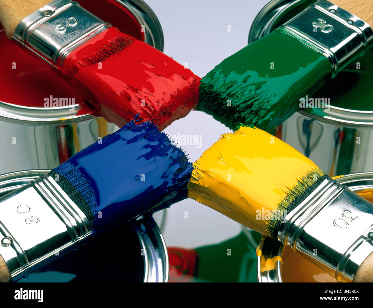 Close-up of four paintbrushes on paint cans Stock Photo