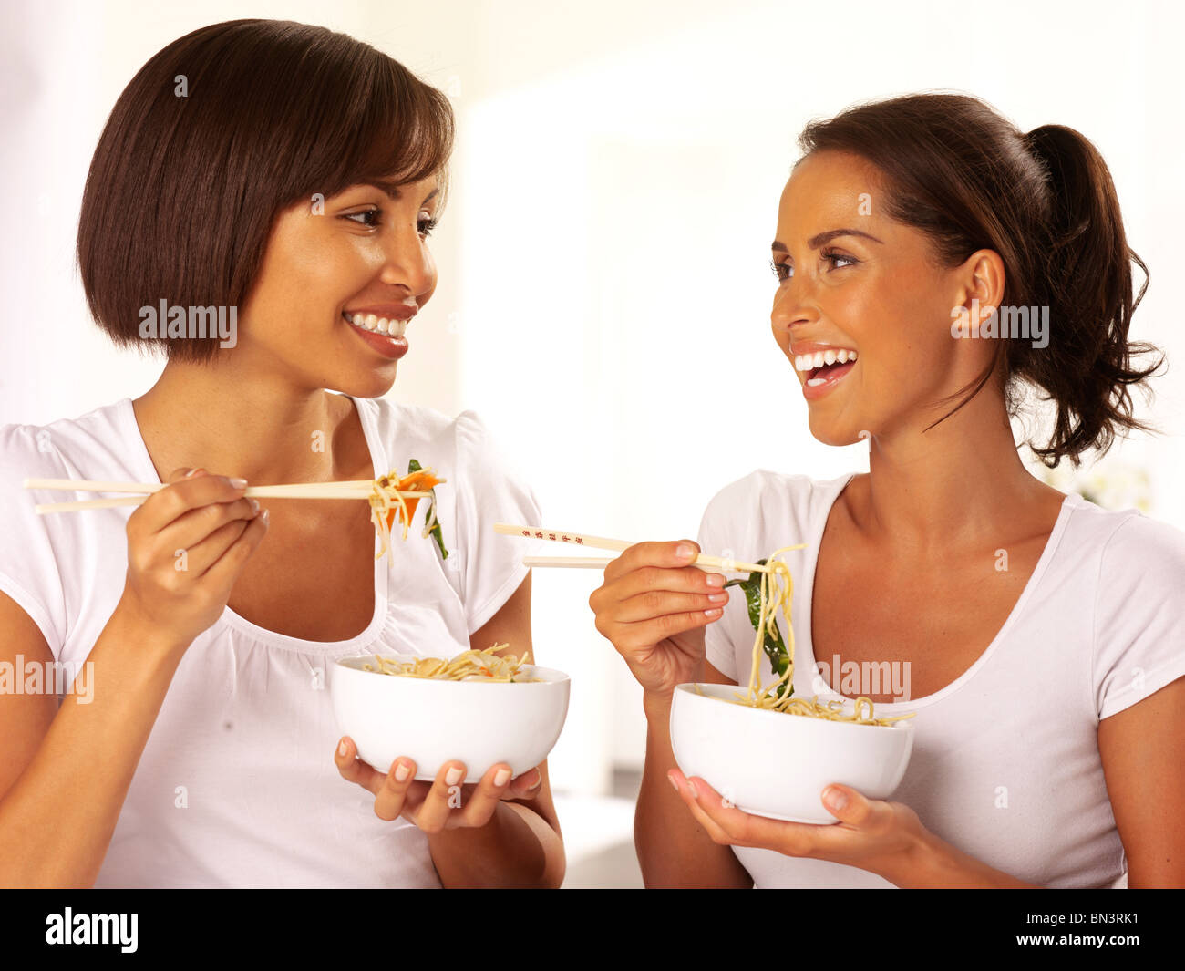 TWO WOMEN EATING NOODLES Stock Photo - Alamy