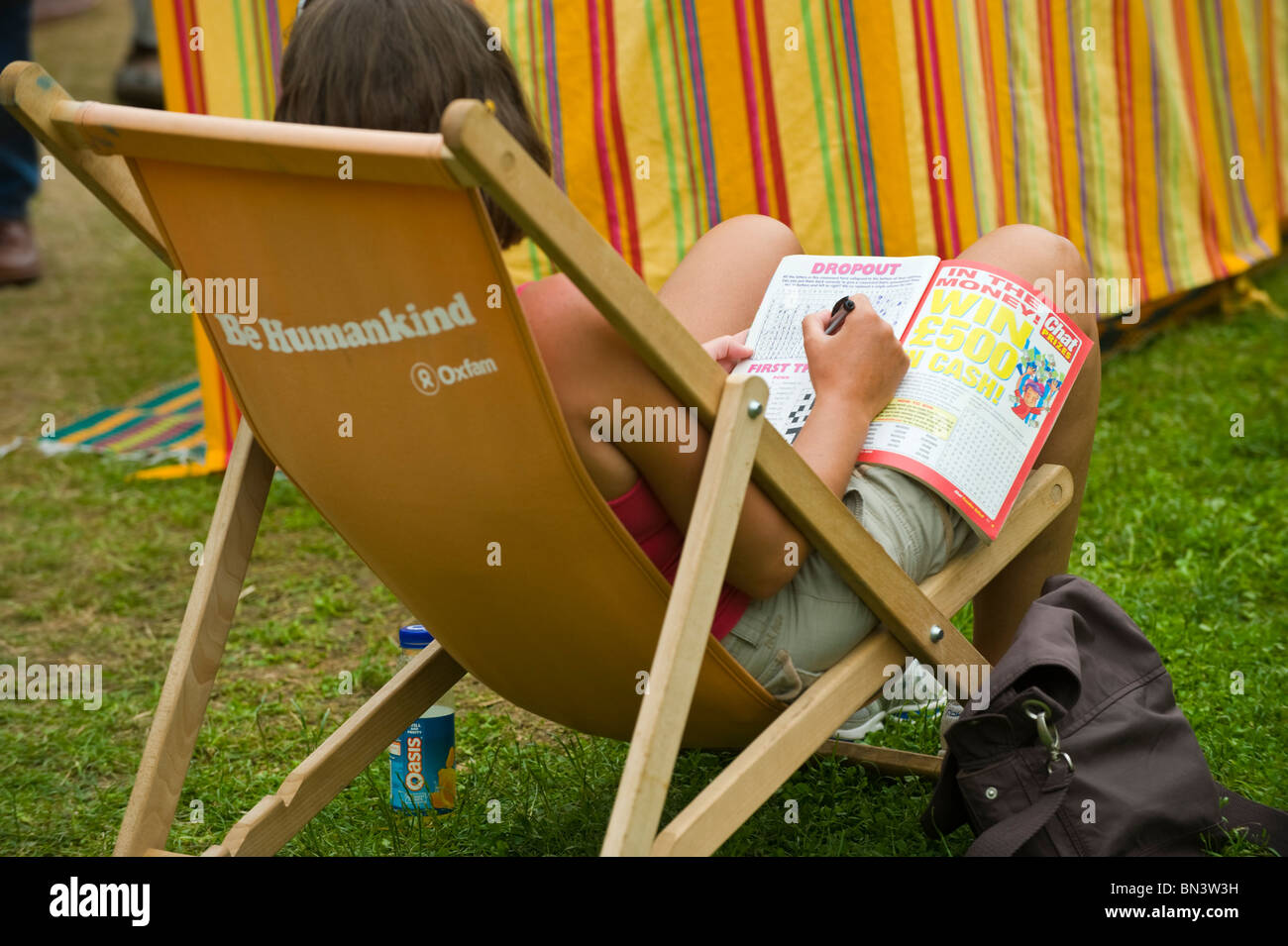 Woman doing crossword sitting in deckchair at Hay Festival 2010 Hay on