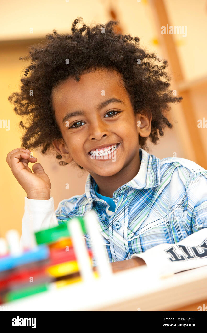 Young boy sitting at a table, portrait Stock Photo Alamy