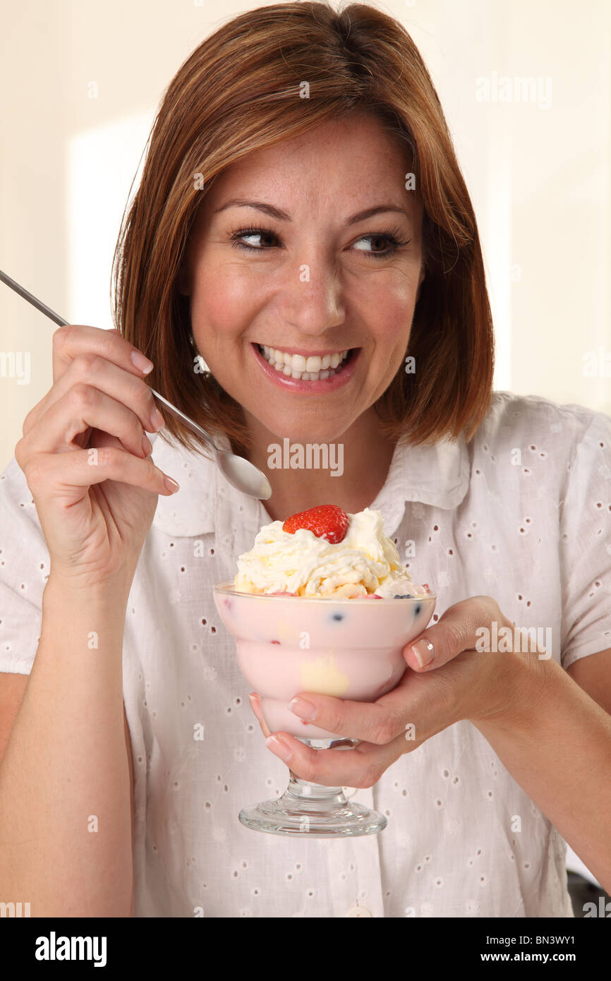 WOMAN EATING ICE CREAM SUNDAE Stock Photo