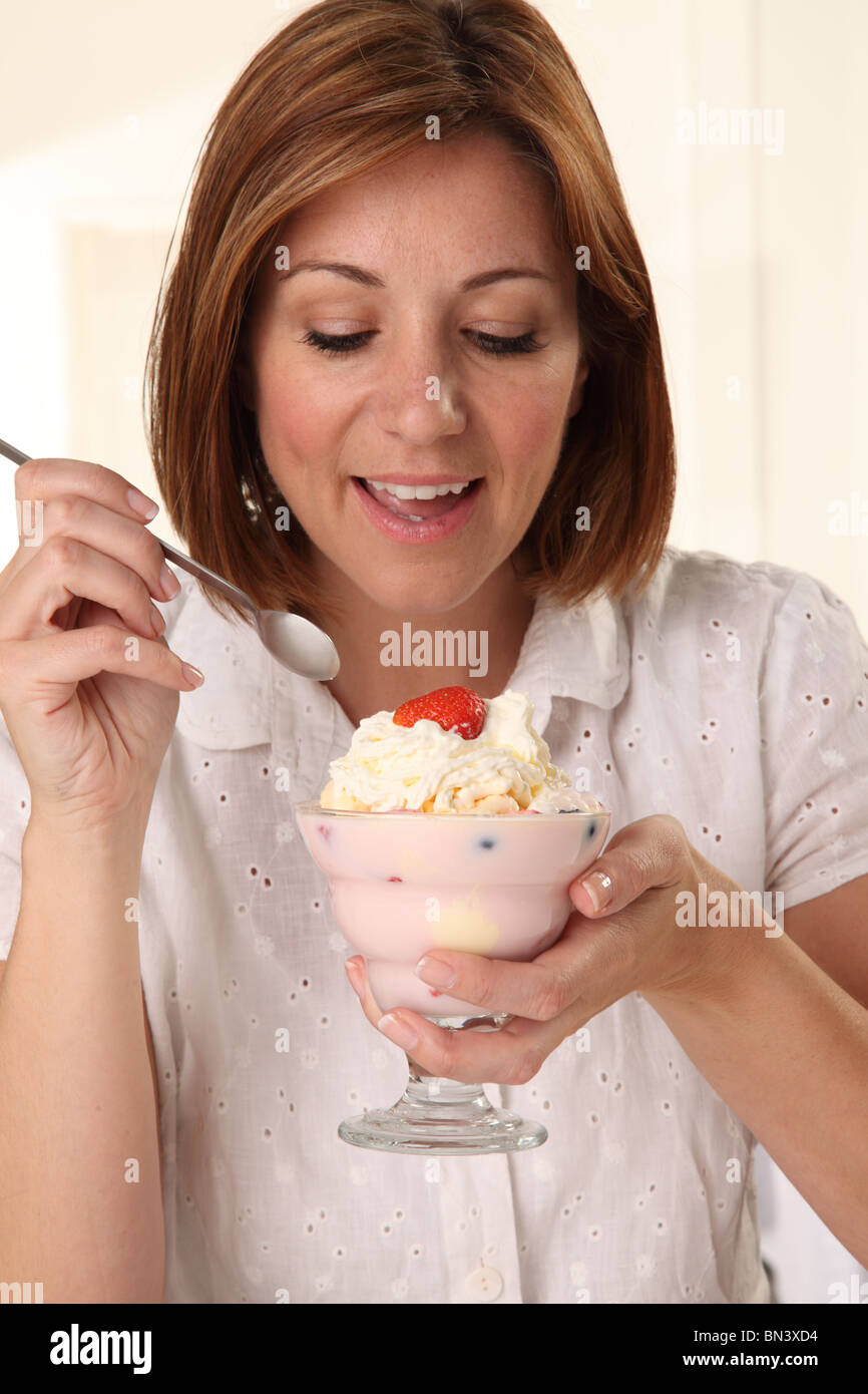 WOMAN EATING ICE CREAM SUNDAE Stock Photo