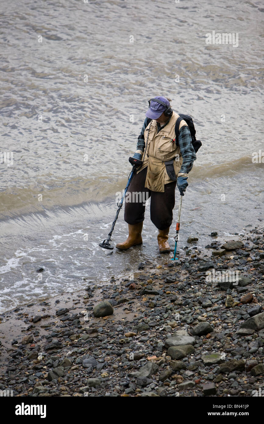 Searching The river bank with a metal detector Stock Photo - Alamy