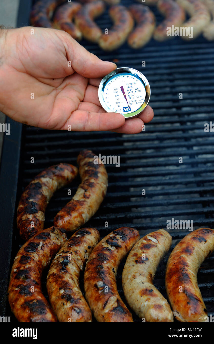 Checking temperature on Sausage grilled on grill outside Stock Photo