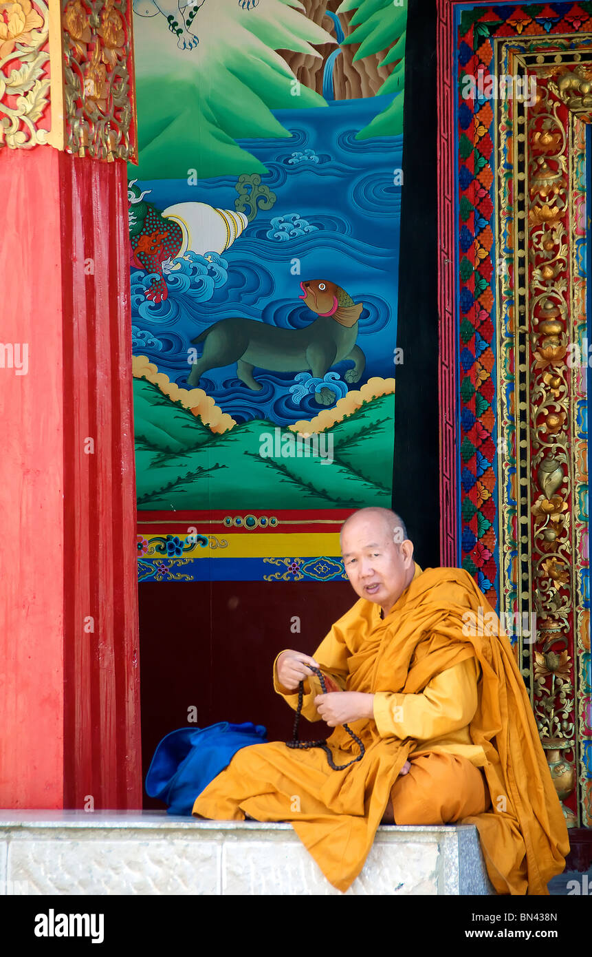 Seated monk in yellow robes Ganden Sumtseling Gompa or Songzanlin Monastery Zhongdian Yunnan China Stock Photo