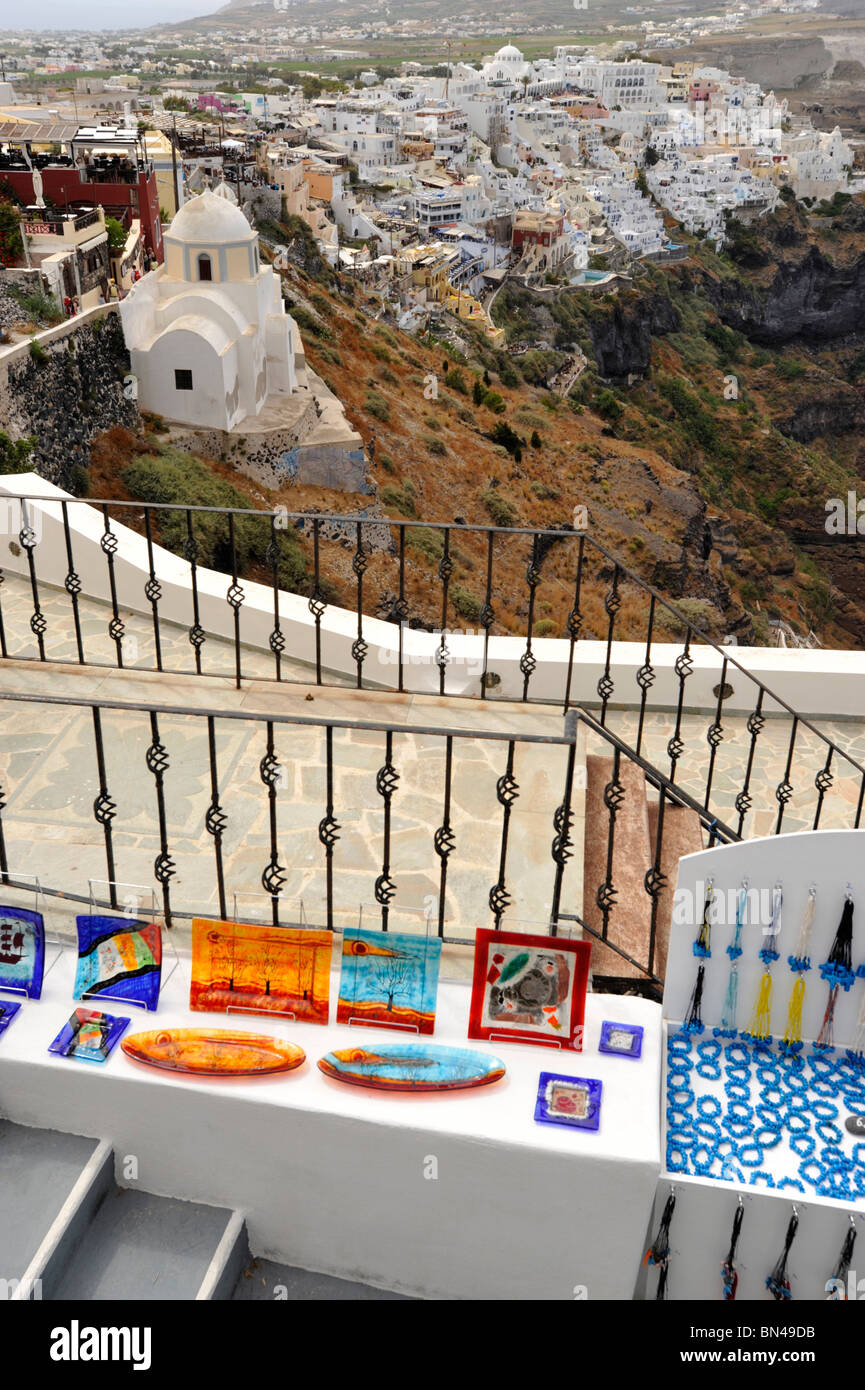 Glass and ceramic Tourist Souvenirs in Santorini with the capital Fira on the horizon Stock Photo