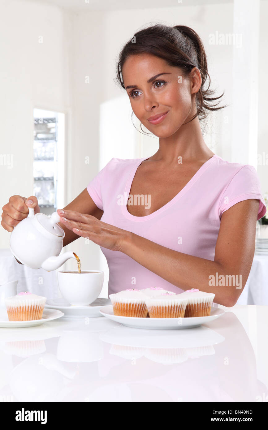 WOMAN WITH TEA AND CUP CAKES Stock Photo