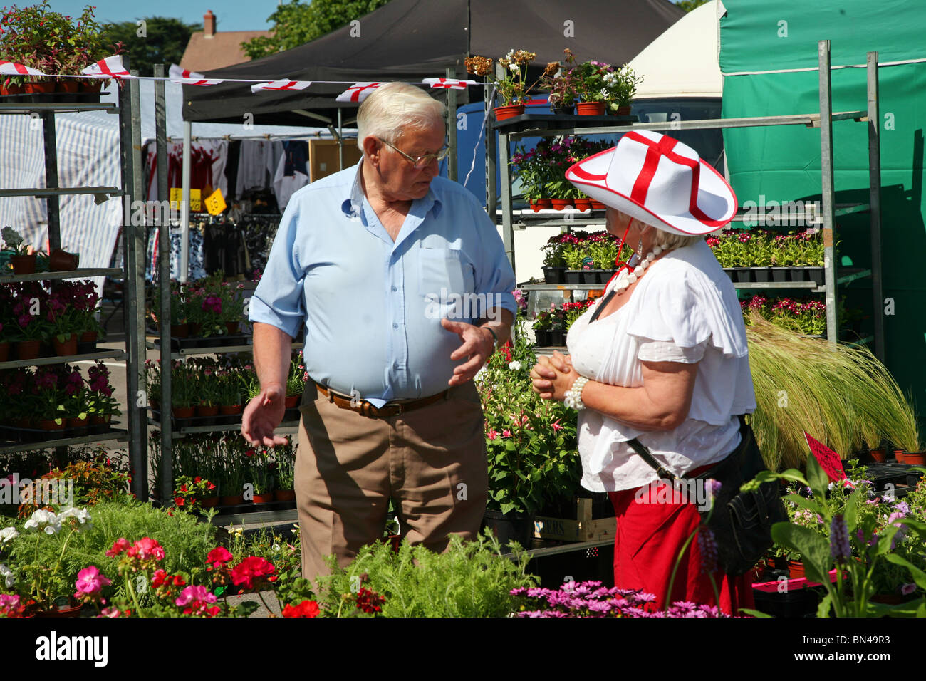 Selecting plants for the garden from a bedding plant stall in Dorchester market Stock Photo