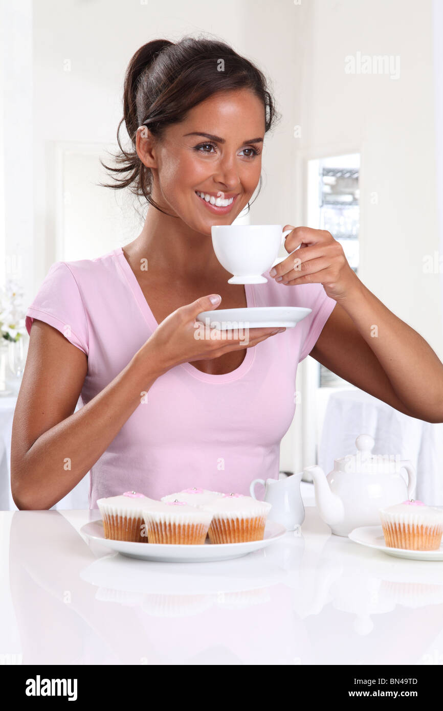 WOMAN WITH TEA AND CUP CAKES Stock Photo