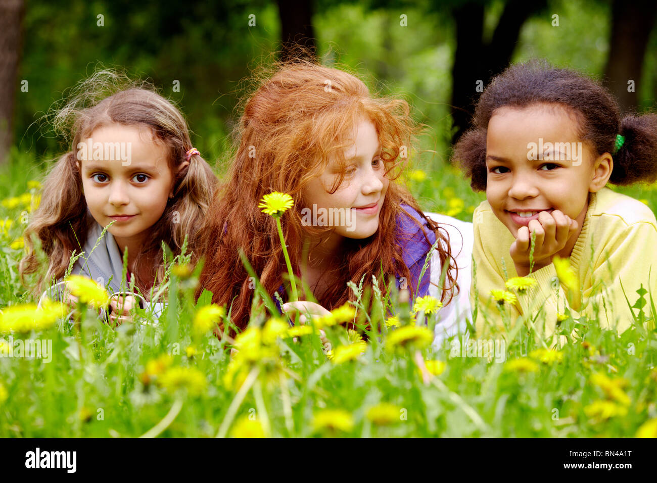 Portrait of friendly girls relaxing in park on summer day Stock Photo