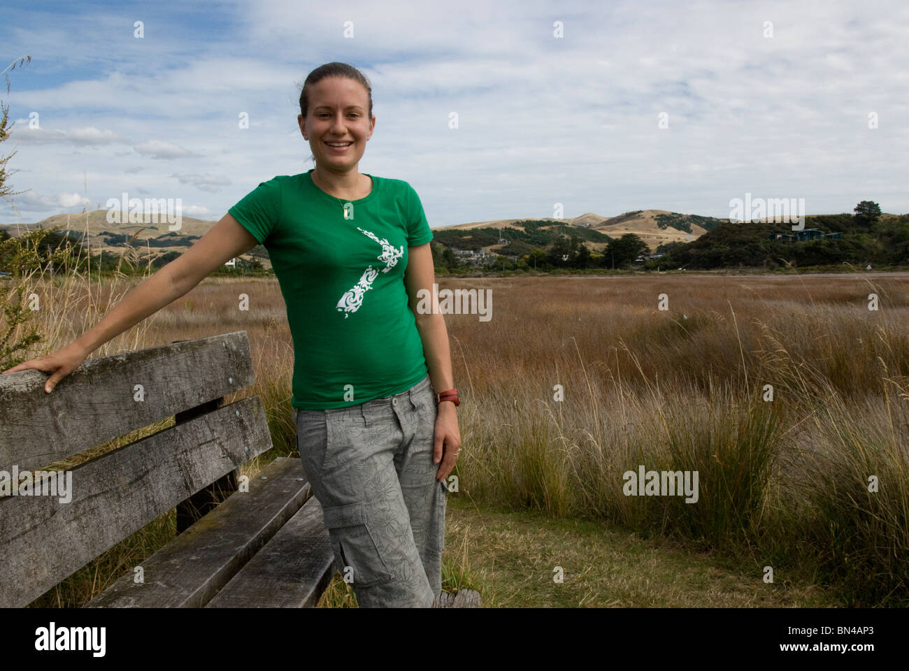 Young woman, 20's, in green New Zealand tee shirt at wildlife reserve, wetland, Pauatahanui Inlet, Wellington, North Island, Stock Photo