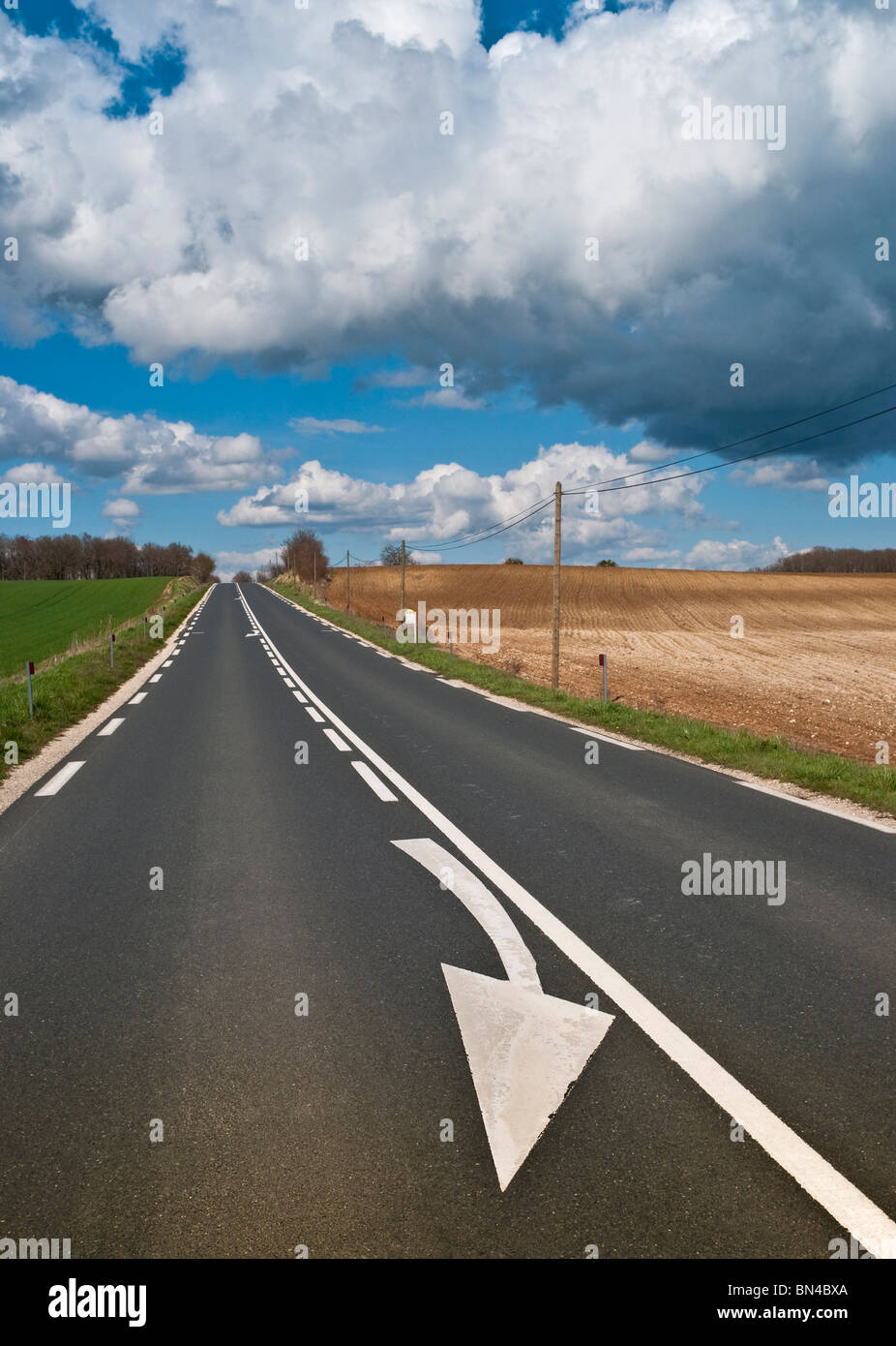 Open road / painted arrow overtaking restriction warning sign on road - Indre, France. Stock Photo