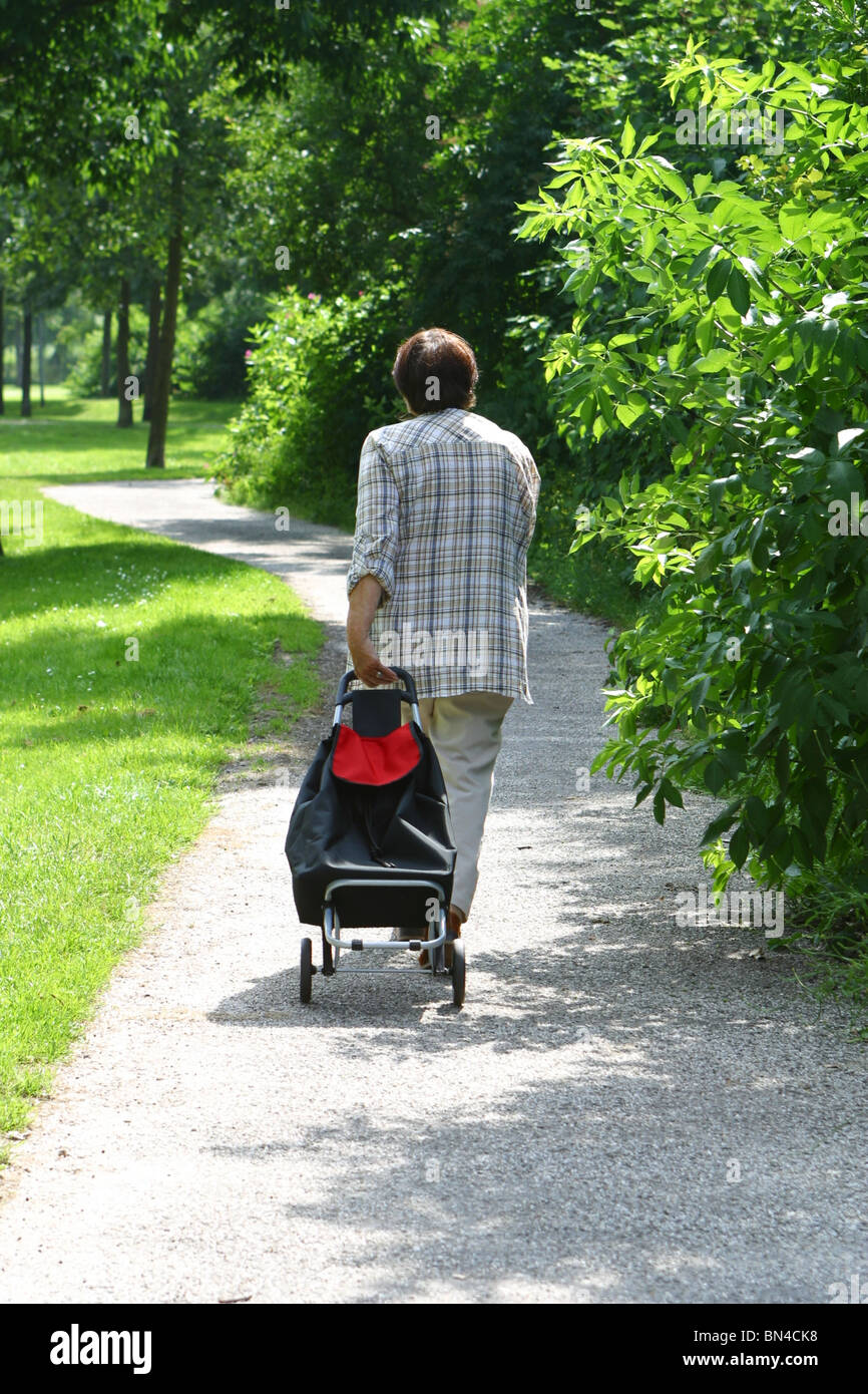 Rear view old woman walk in park Stock Photo