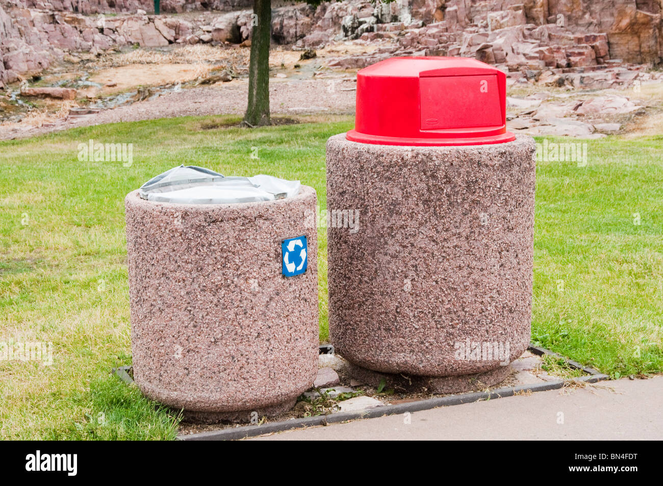 Garbage and recycling cans in a public park conveniently located along the sidewalk to encourage resopnsible behavior. Stock Photo