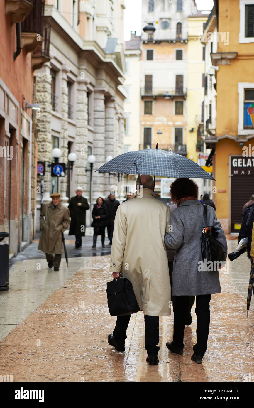 People walking in the rain down a street in Verona, Italy Stock Photo ...