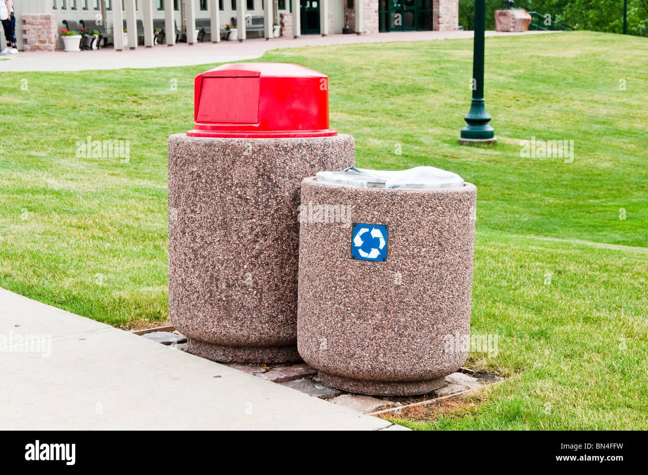 Garbage and recycling cans in a public park conveniently located along the sidewalk to encourage resopnsible behavior. Stock Photo