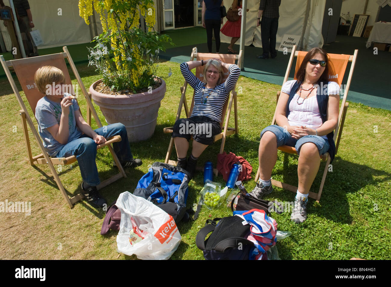 Two women and young boy sitting in deckchairs relaxing in the sunshine at Hay Festival 2010 Hay on Wye Powys Wales UK Stock Photo