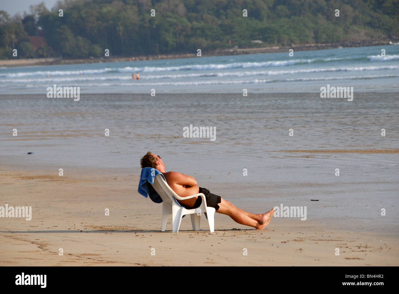 Foreign tourist relaxing in a chair on Ao Khlong Dao beach , Ko Lanta Island, Andaman Sea, southern Thailand Stock Photo