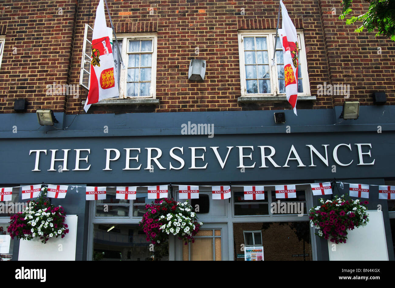 Perseverance pub with line of english flags and hanging baskets of flowers Stock Photo