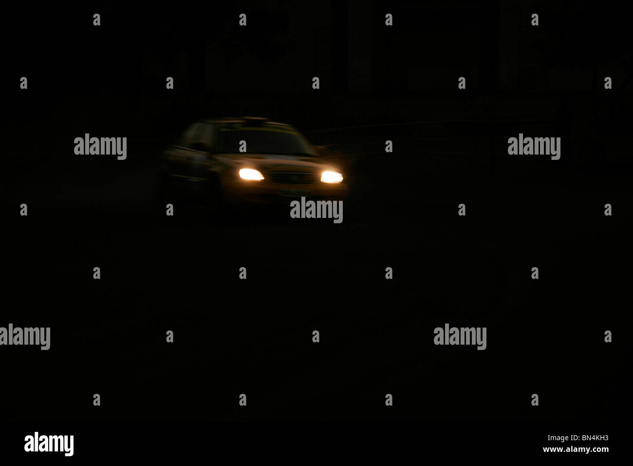 Yellow car with headlights on taking speedy turn in race held at