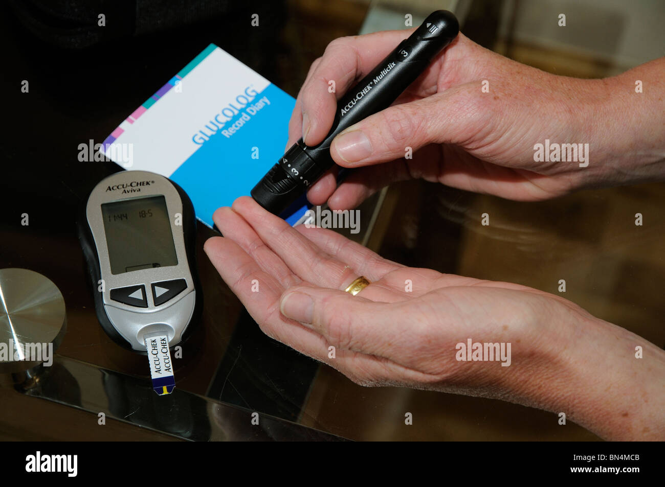 Patient using blood glucose testing kit finger pricker to establish human  blood glucose level Stock Photo - Alamy