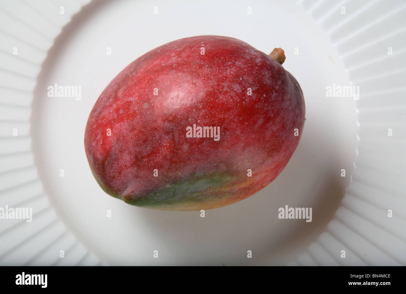 Fruit ; Red Mango ; Sweet ; Sour test ; Colourful ; One mango in a plate ; India Stock Photo